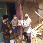 Anggota Polsek Cibugel saat menyerahkan bantuan beras 5 kg kepada warga terdampak covid-19
